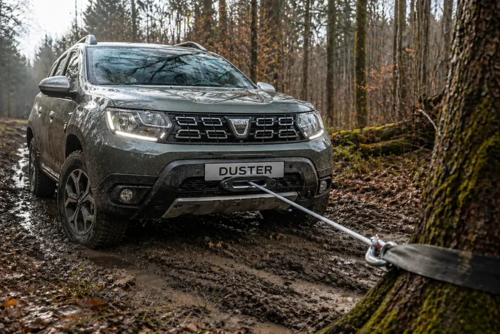 Dacia Duster équipé d'un treuil électrique 12v en cours d'extraction sur piste boueuse en forêt