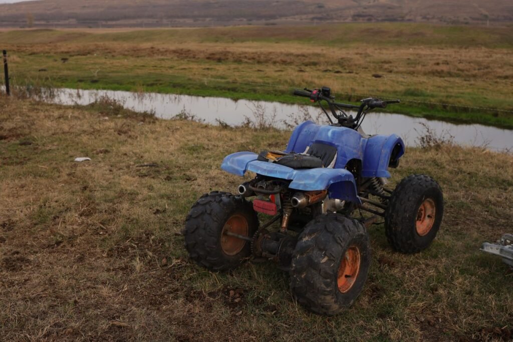 Quad garé dans un champ, usage typique d'un mini treuil électrique 12V