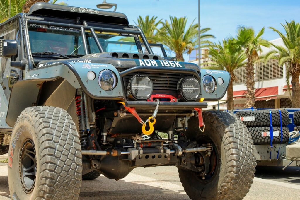 4x4 de raid préparé avec un treuil électrique et un crochet à l'avant, garé au soleil